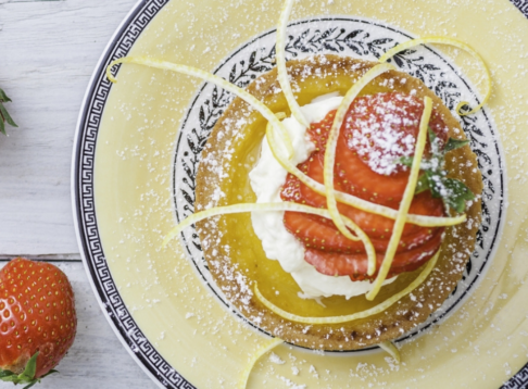 tart on a plate topped with strawberries and cream